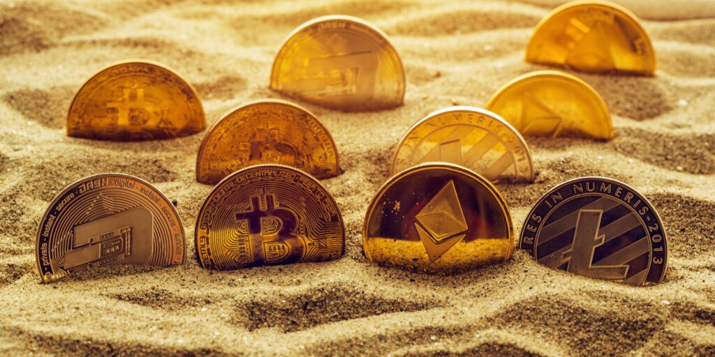Cryptocurrency coins in sand
